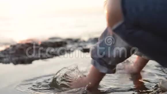 一个小女孩在海边泼海水特写视频的预览图