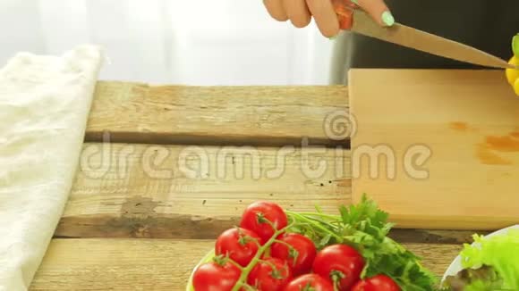 女人手里拿着一把刀把黄椒从芯子上擦干净视频的预览图