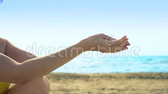 沙子在天空和大海的背景下流过手指视频的预览图