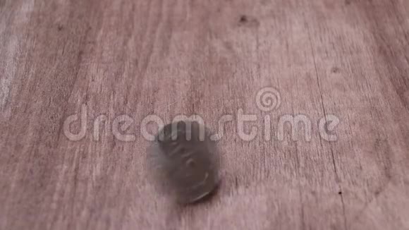 在木制地板上旋转5泰铢以古泰货币的非形状并以硬币的反向停止视频的预览图