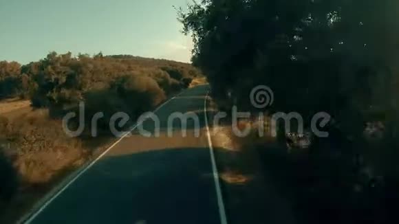 阳光明媚的夏日一条乡村道路的低空航拍镜头视频的预览图