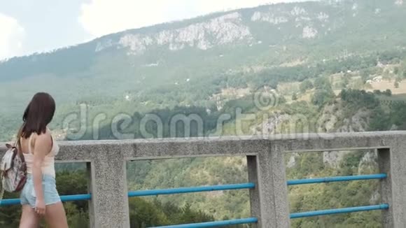 站在黑山Djurdjevic桥上的旅游女孩侧景旅游生活方式视频的预览图