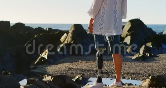 残疾妇女站在海滩上双臂张开视频的预览图