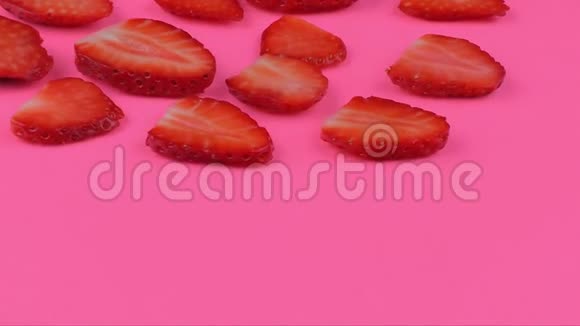 旋转草莓片在粉红色背景4K决议视频的预览图