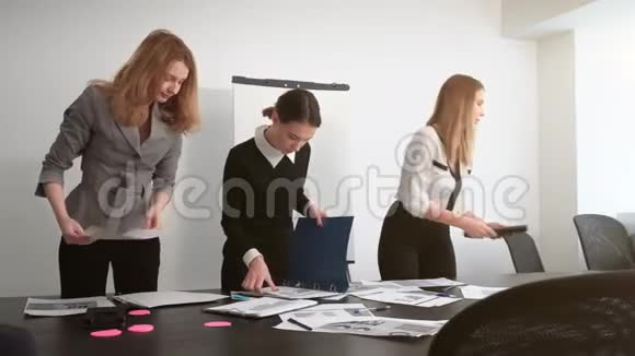 女孩们正在收拾桌子上的文件视频的预览图