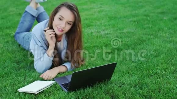 利用笔记本电脑从事公园自由职业的年轻女性视频的预览图