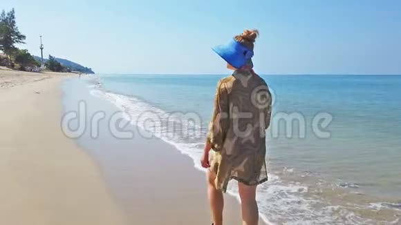 女人在沙滩上行走沙滩上有黄沙和海水视频的预览图