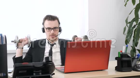 穿西装的年轻人在办公室工作用哑铃做肩膀练习60英尺视频的预览图