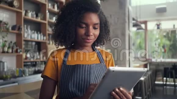 微笑的女咖啡馆老板用数码平板电脑视频的预览图