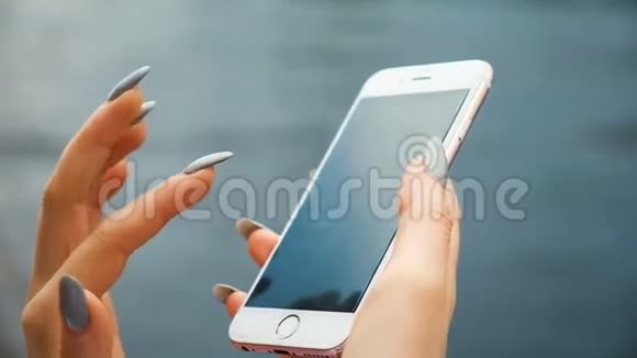 商务女性留着长长的指甲和头发在电话特写中打印一条信息欧洲女孩使用智能手机视频的预览图