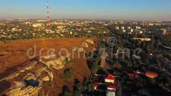 在有荒地的岩石之后城市建筑开始了鸟的视野视频的预览图