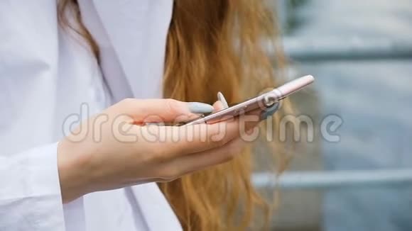商业女性留着长长的指甲和头发打印一个信息特写欧洲女孩使用智能手机的本质慢动作视频的预览图