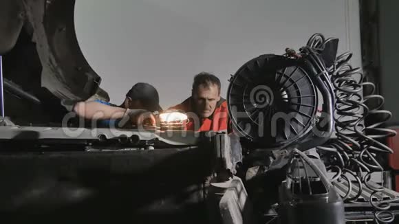 两个带灯的汽车机械师寻找卡车发动机的断裂视频的预览图