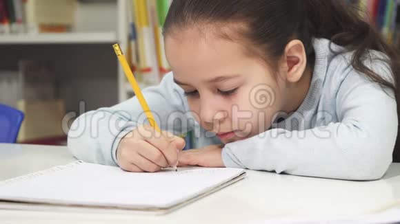 可爱的小女孩在笔记本上画画视频的预览图