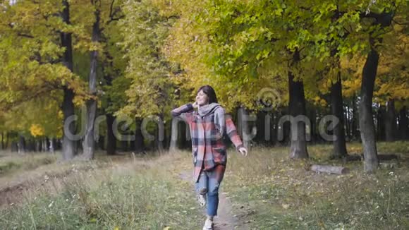 去掉口袋里的手特写秋天的女孩在城市公园散步快乐可爱和美丽的肖像视频的预览图
