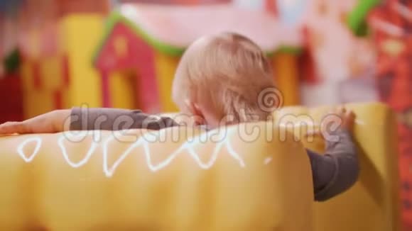 金发小孩坐在黄色大车椅上视频的预览图