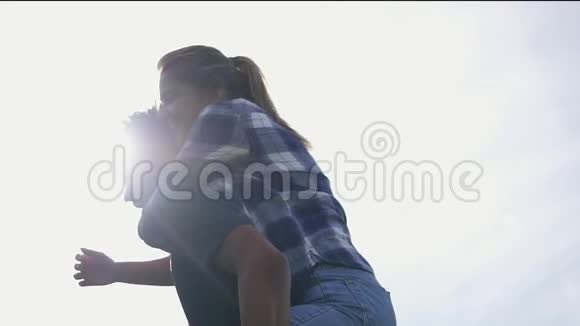 特写镜头一个英俊的非洲男人背着他的白种人快乐的女朋友对抗太阳镜头耀斑视频的预览图