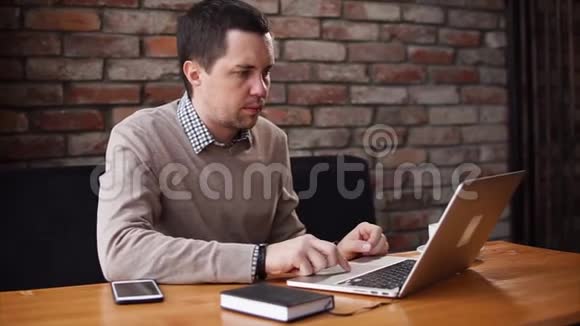 一个成年人在咖啡馆里检查笔记本电脑上的信件其次是智能手机视频的预览图