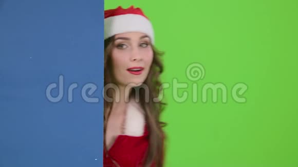 雪少女窥视显示一个手指在一个蓝色板广告广告牌绿色屏幕慢动作视频的预览图