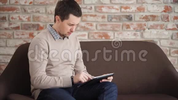 这个人在平板电脑上打印文本手里拿着一个小玩意用互联网视频的预览图