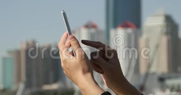 一个女孩使用智能手机崇尚现代商业建筑背景视频的预览图