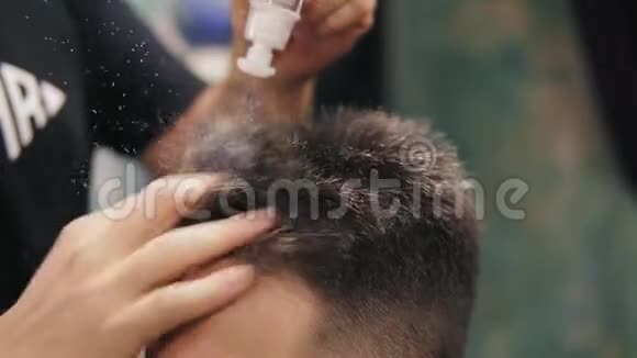 理发店里一位理发师将粉末涂在顾客头上的特写镜头时尚的专业发型视频的预览图