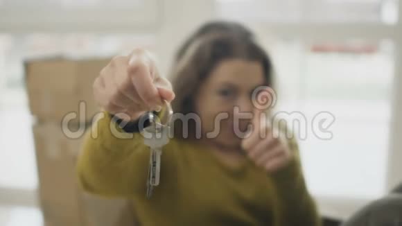 幸福的女人伸出大拇指拿出新房子的钥匙视频的预览图