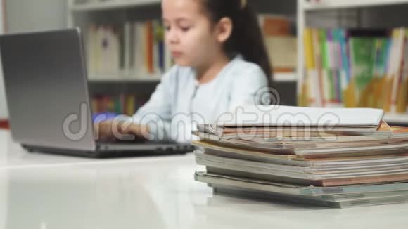 小女孩在学校用笔记本电脑做作业视频的预览图
