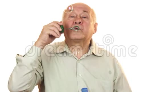 年长开朗的人吹着白色的泡泡视频的预览图
