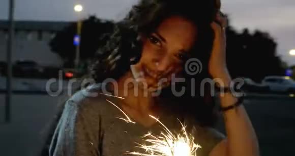 黄昏时分美丽的少女在城市街道上燃放烟花视频的预览图