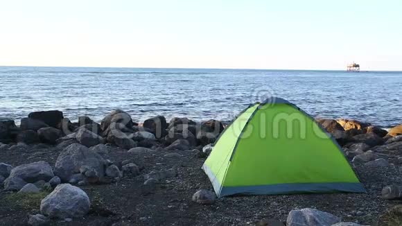 黎明时分在石质海滩上顶着天空的旅游帐篷静态摄像机视频的预览图