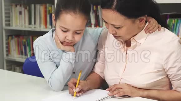 快乐成熟的亚洲女人帮助她的小女儿学习视频的预览图