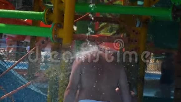 一个人站在水上公园里背对着水一股水流在缓慢的运动中流动泼水视频的预览图