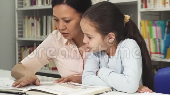 亚洲成熟的女人和她可爱的小女儿一起看书视频的预览图