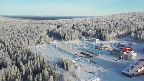 鸟瞰现代滑雪基地酒店和停车场周围的森林在冬天蓝天录像从这里看视频的预览图