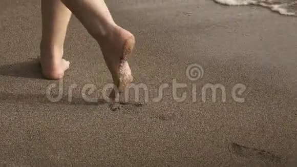 清晨在沙滩上的热带沙滩上雌性的双腿在海浪中伸展开来视频的预览图