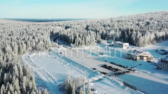 鸟瞰现代滑雪基地酒店和停车场周围的森林在冬天蓝天录像从这里看视频的预览图