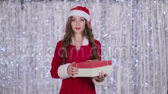 手里拿着礼物的圣诞女孩更安静地伸出手指博克背景慢动作视频的预览图
