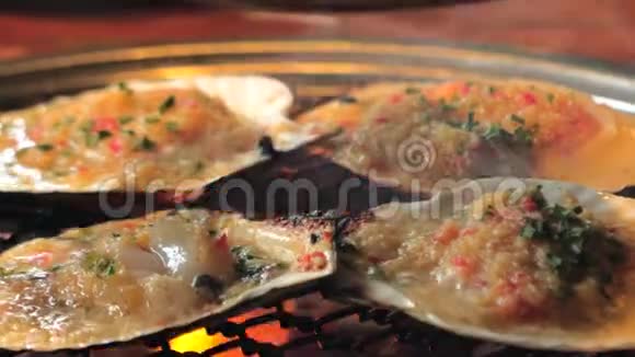大型新鲜扇贝壳海鲜烤架上金属网与木炭烧烤在韩国餐厅烧烤烹饪风格视频的预览图
