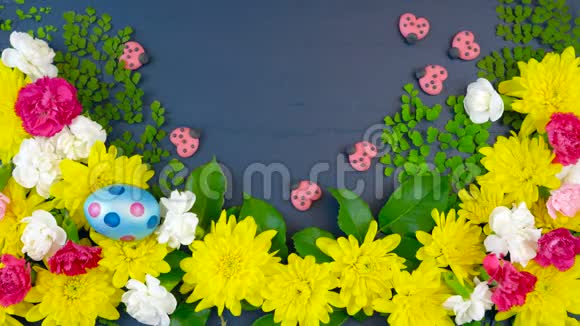 复活节的头顶上在深蓝色的木头上展出新鲜的春花视频的预览图