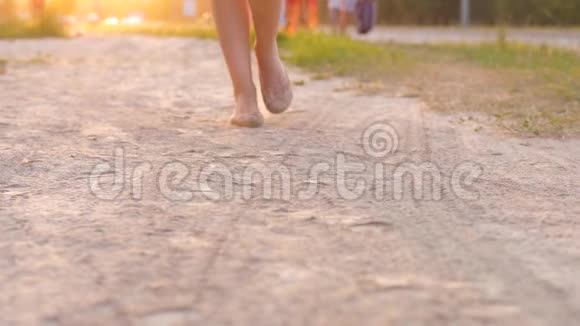 女足穿着平底鞋走在尘土飞扬的小路上视频的预览图