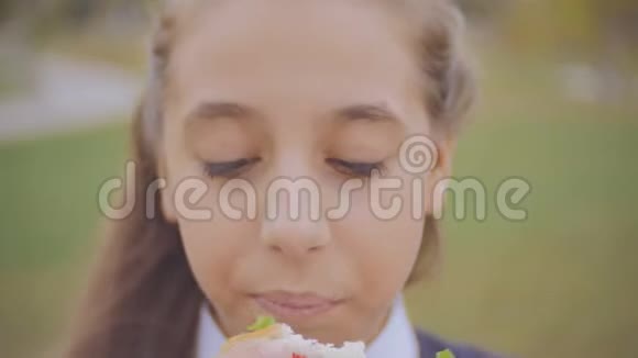 在花园学校外面吃三明治的高中生的特写照片视频的预览图