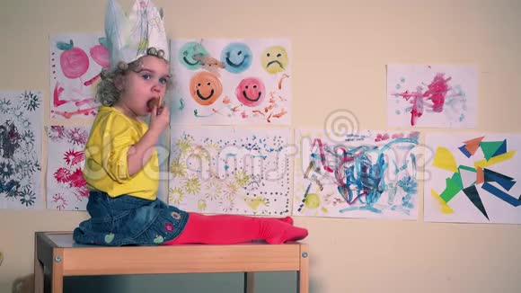 带着纸冠的幼儿坐在小桌子上吃饼干视频的预览图