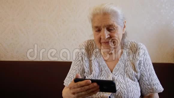 快乐的慢动作肖像是一老年妇女使用智能手机和微笑视频的预览图