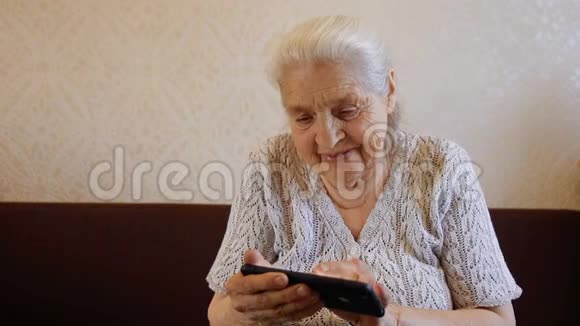 使用智能手机和微笑的快乐老妇人的慢动作肖像视频的预览图