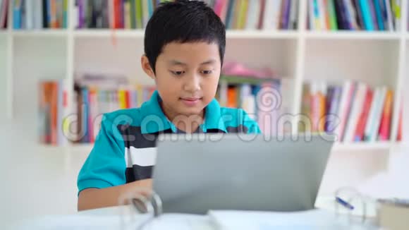 十几岁的小男孩用笔记本电脑学习视频的预览图
