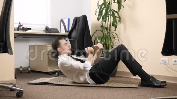 穿西装的年轻人在办公室里以每秒60帧的速度做腹部运动视频的预览图