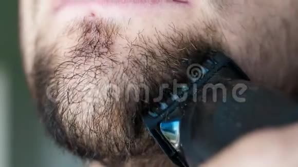 用黑色剃刀把胡子贴在脸上刮胡子的人用剃刀刮下巴视频的预览图
