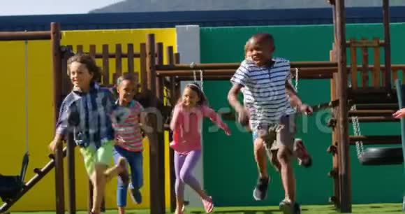 混合种族学童在学校操场玩耍的正面景色视频的预览图