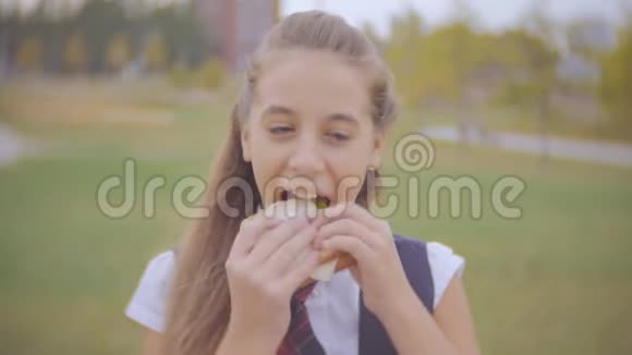在花园学校外面吃三明治的高中生的特写照片视频的预览图